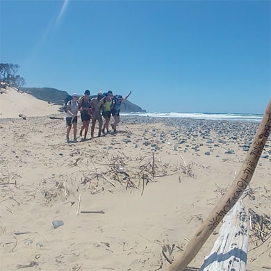 Happy hikers link arms with their tour guide at the end of the hiking trail